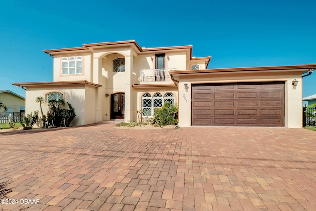 mediterranean / spanish house featuring a garage and a balcony