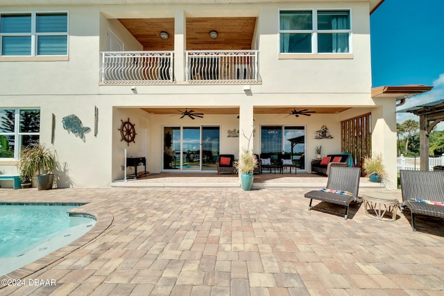 rear view of house featuring a patio area, ceiling fan, and a balcony