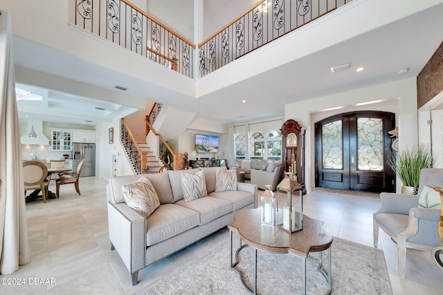 living room with a towering ceiling and french doors