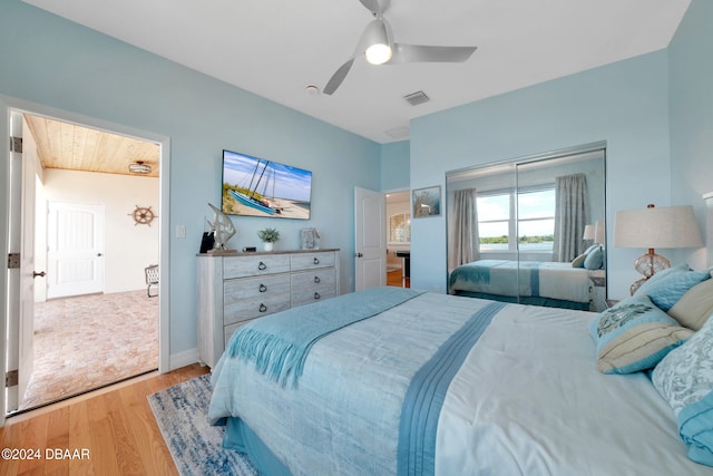 bedroom featuring light hardwood / wood-style floors, ceiling fan, and a closet