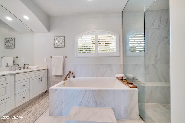 bathroom with vanity and tiled bath