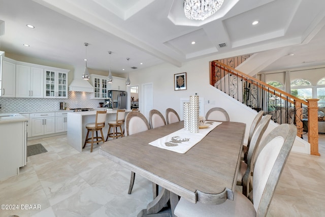 dining area with beamed ceiling and sink