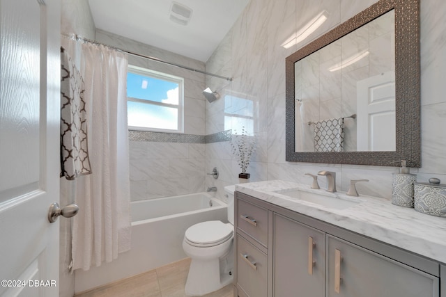 full bathroom featuring tile walls, vanity, shower / bath combo with shower curtain, and tile patterned floors