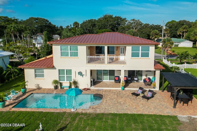 back of house with a patio, a lawn, and a balcony