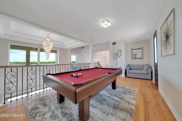 recreation room featuring hardwood / wood-style floors, a notable chandelier, pool table, and a tray ceiling