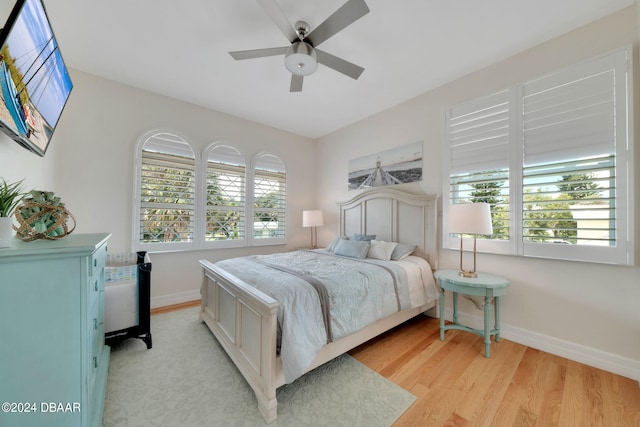 bedroom with light wood-type flooring, multiple windows, and ceiling fan