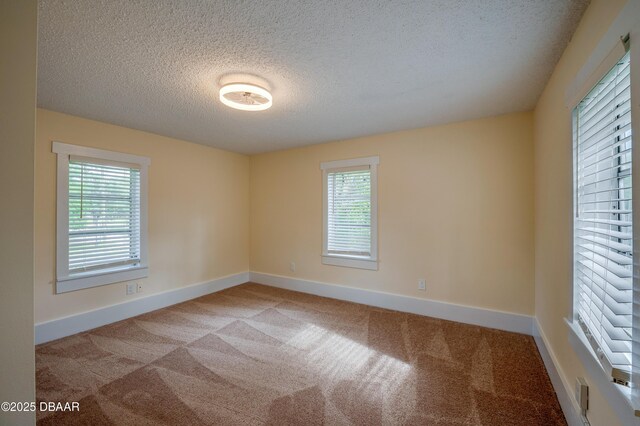 84 Lincoln Ave, Ormond Beach, FL 32174 - carpeted empty room featuring a textured ceiling, plenty of natural light, and baseboards