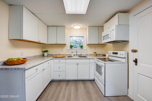84 Lincoln Ave, Ormond Beach, FL 32174 - kitchen featuring white appliances, a sink, a paneled ceiling, light wood finished floors, and white cabinetry