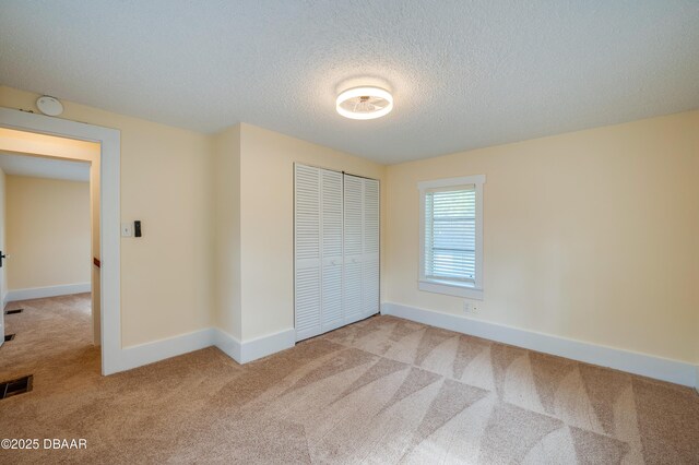 84 Lincoln Ave, Ormond Beach, FL 32174 - unfurnished bedroom featuring carpet flooring, a closet, a textured ceiling, and baseboards