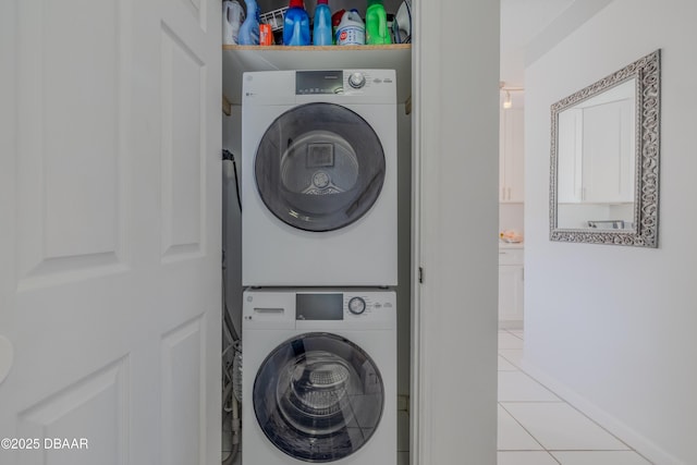 clothes washing area with light tile patterned floors and stacked washer / drying machine