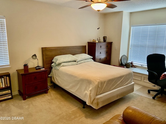 bedroom featuring light carpet, a textured ceiling, and a ceiling fan