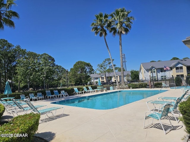 pool with a patio and fence