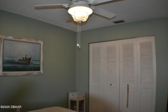 bedroom with a closet, a ceiling fan, and visible vents