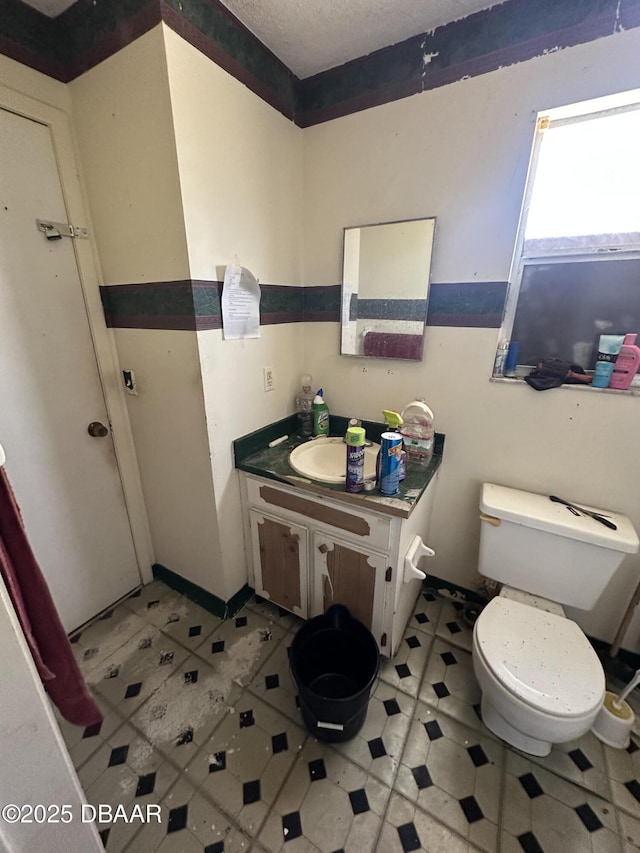 bathroom with vanity, a textured ceiling, and toilet