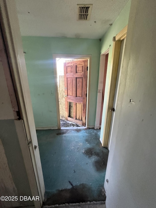 hall with concrete flooring and a textured ceiling