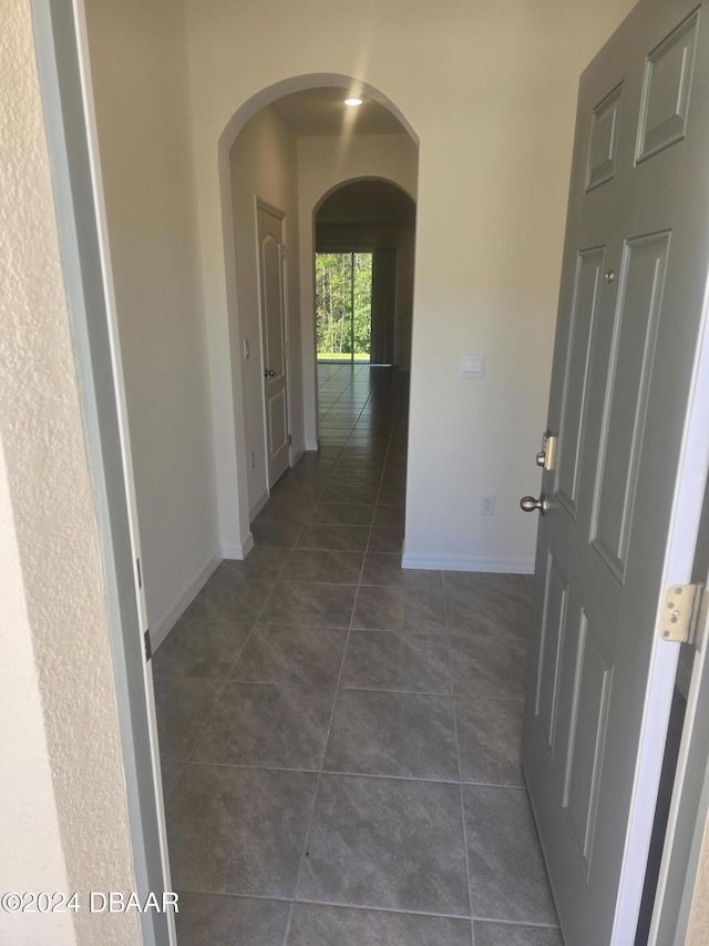 hallway with dark tile patterned flooring