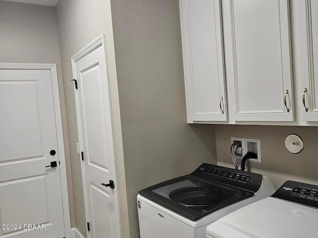 laundry area with washing machine and dryer and cabinets