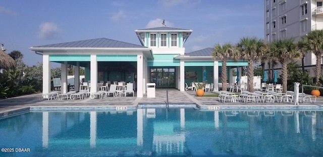 rear view of house featuring a gazebo, a community pool, and a patio