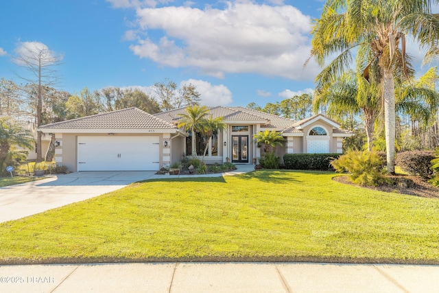 mediterranean / spanish home featuring a front lawn and a garage