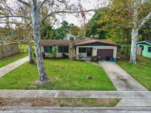 single story home with driveway, a front lawn, and an attached garage