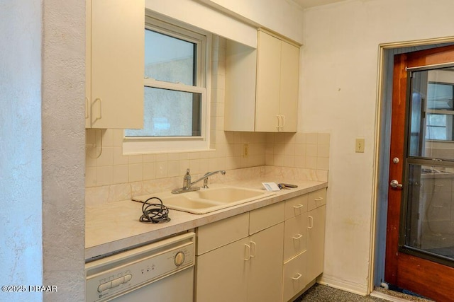 kitchen featuring light countertops, white dishwasher, a sink, and decorative backsplash