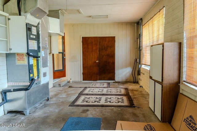 interior space featuring wood walls and unfinished concrete flooring