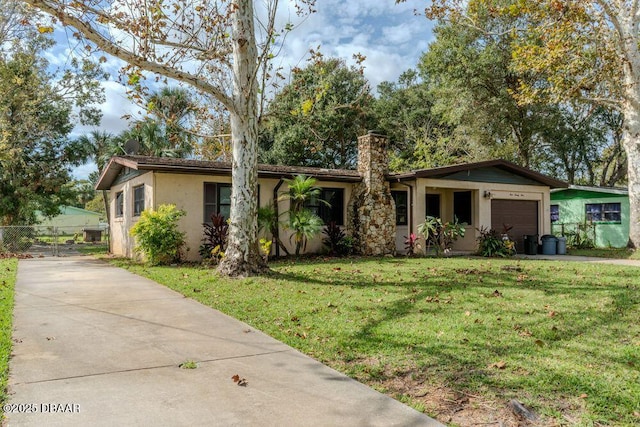 ranch-style house with a garage, driveway, a chimney, a front lawn, and stucco siding