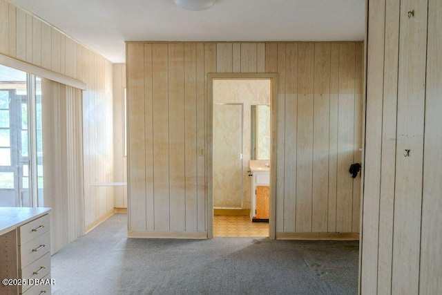 unfurnished bedroom with carpet and wood walls