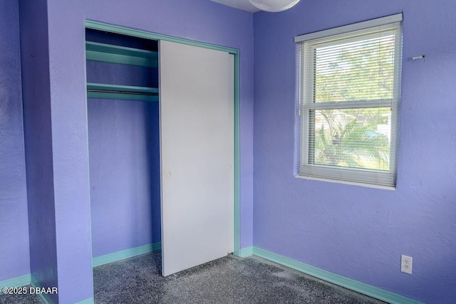 unfurnished bedroom featuring baseboards and a closet