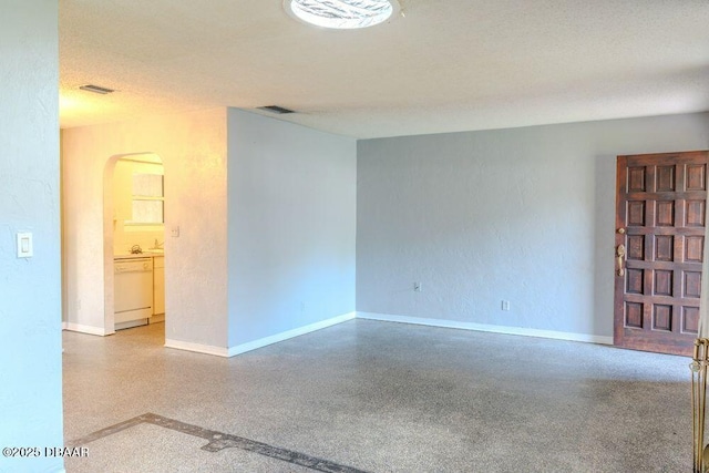 unfurnished room featuring arched walkways, visible vents, a textured ceiling, and baseboards