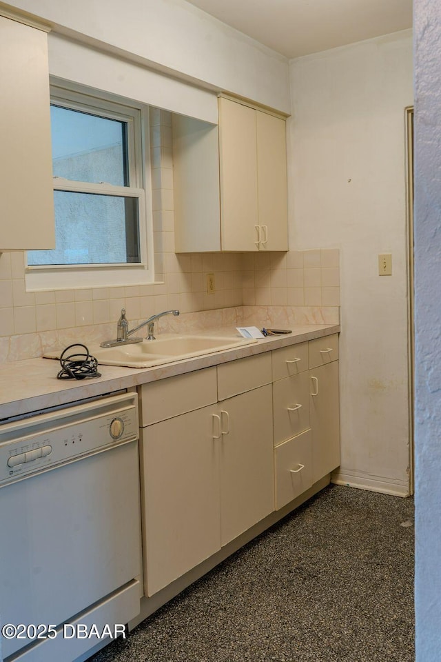 kitchen featuring dishwasher, backsplash, light countertops, white cabinetry, and a sink