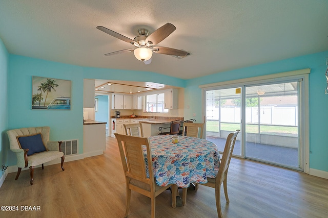 dining area featuring ceiling fan, a textured ceiling, and light hardwood / wood-style flooring