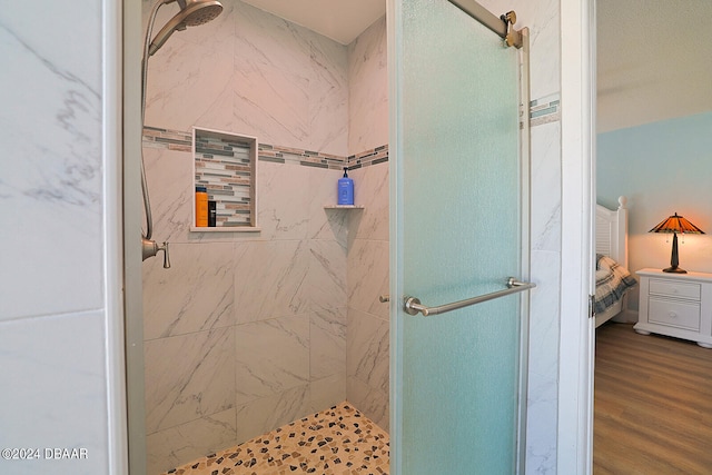 bathroom featuring hardwood / wood-style flooring and a shower with shower door