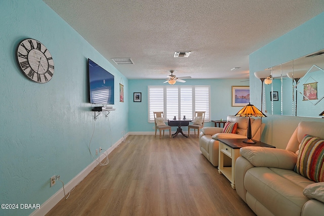 living room featuring a textured ceiling, hardwood / wood-style flooring, and ceiling fan