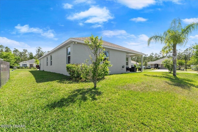 exterior space featuring stucco siding and a lawn