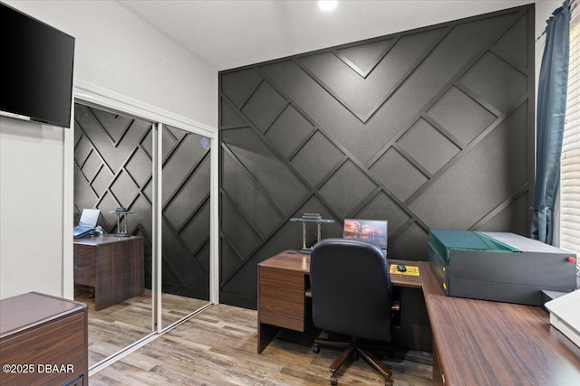 home office with a decorative wall and wood finished floors
