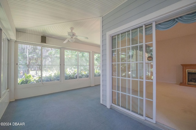 unfurnished sunroom with ceiling fan