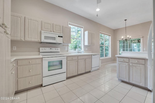 kitchen featuring a chandelier, sink, light tile patterned flooring, white appliances, and decorative light fixtures