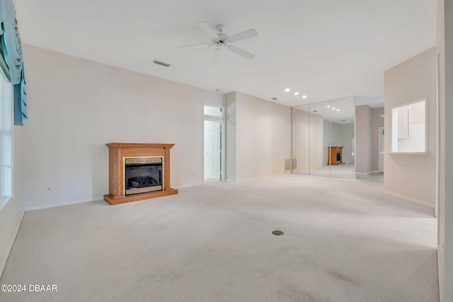 unfurnished living room with light carpet and ceiling fan