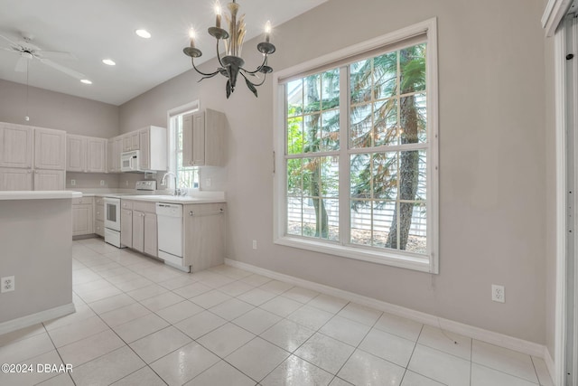 kitchen featuring a wealth of natural light, white cabinetry, white appliances, and light tile patterned floors