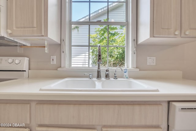 kitchen featuring light brown cabinets, white appliances, and sink