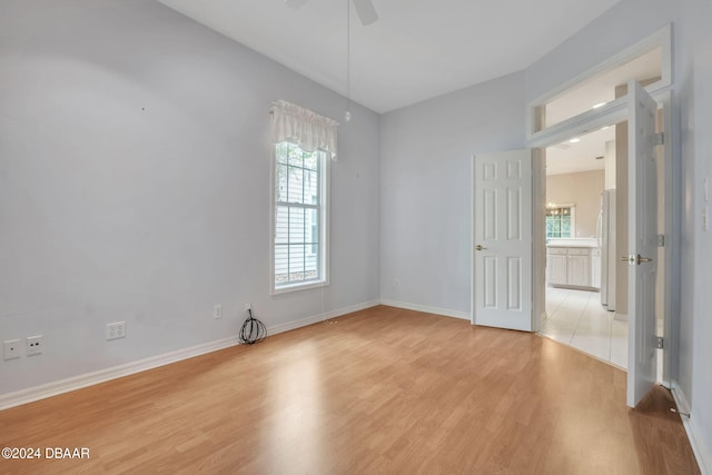 unfurnished room featuring light hardwood / wood-style floors, ceiling fan, and a healthy amount of sunlight