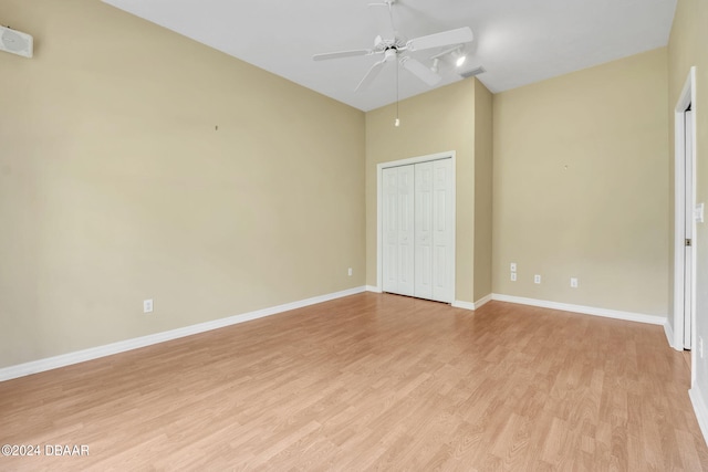 unfurnished bedroom with light wood-type flooring, ceiling fan, and a closet