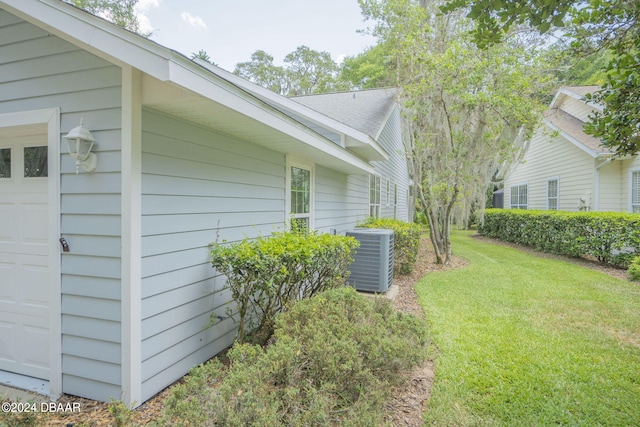 exterior space with central AC unit and a lawn