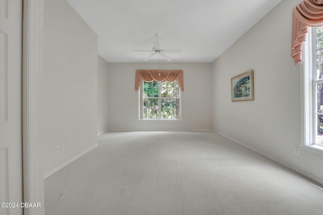 carpeted empty room featuring a wealth of natural light and ceiling fan