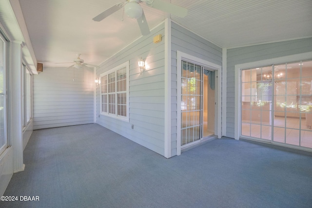 unfurnished sunroom with ceiling fan