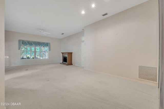 unfurnished living room featuring light colored carpet and ceiling fan