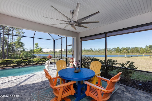 sunroom / solarium featuring ceiling fan and a water view