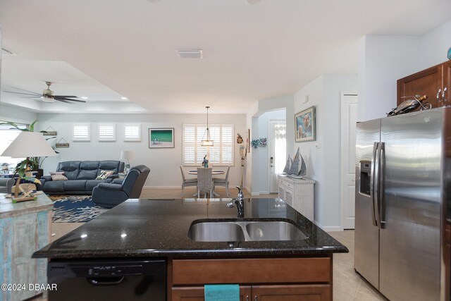 kitchen featuring dishwasher, sink, hanging light fixtures, dark stone countertops, and stainless steel fridge with ice dispenser