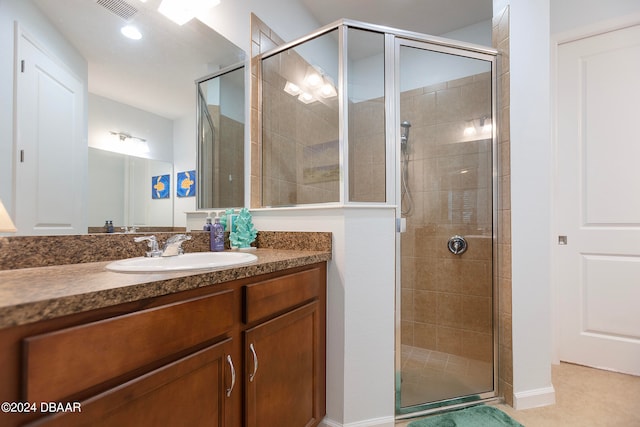 bathroom with tile patterned floors, a shower with door, and vanity